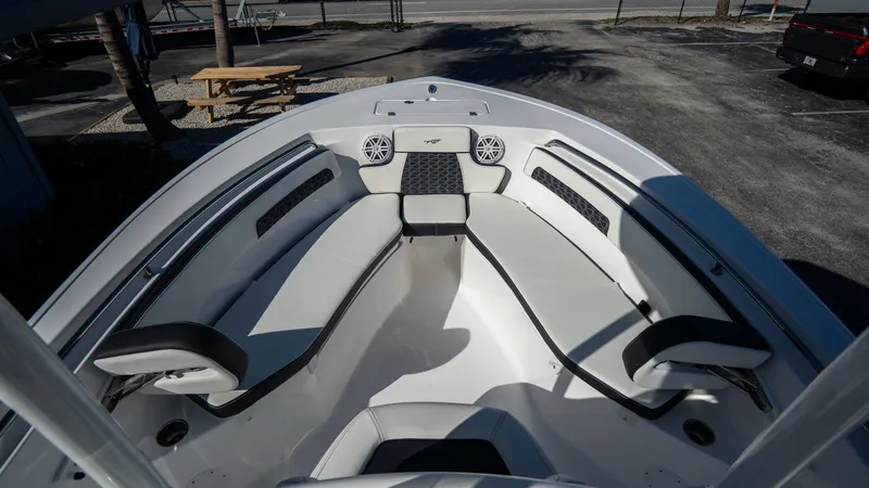 Slide: The Image of 2025 Tidewater 220 LXF boat interior with cushioned seating and speakers. - 20