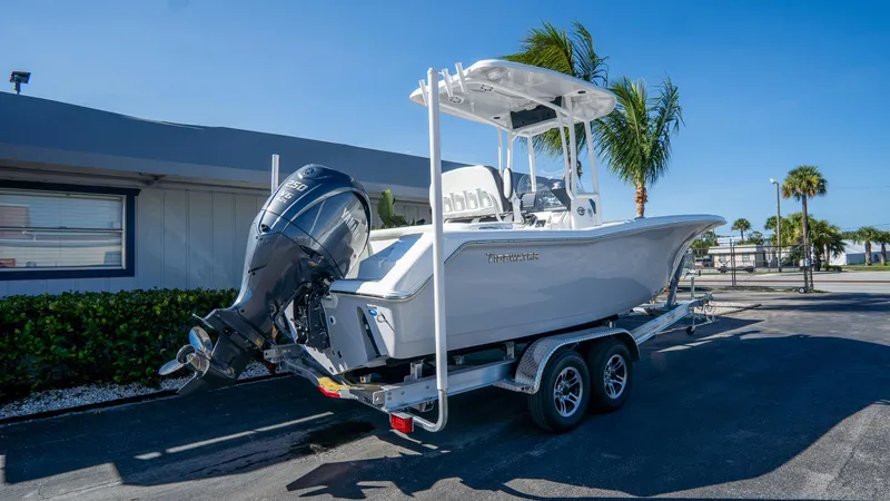 Slide: The Image of 2025 Tidewater 220 LXF boat on trailer, parked outdoors under clear blue sky. - 3