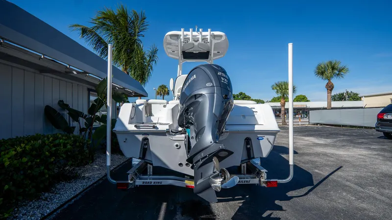 Slide: The Image of 2025 Tidewater 220 LXF boat with outboard motor, parked outdoors under clear blue sky. - 4