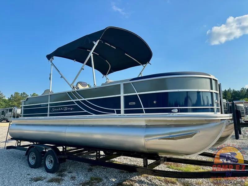 The Image of 2025 South Bay 224FCR LE pontoon boat on a trailer with a black canopy. - 0