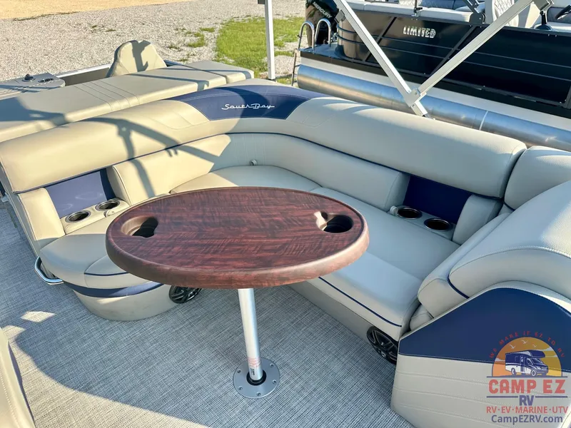 Slide: The Image of 2025 South Bay 224FCR LE pontoon boat interior with cushioned seating and wooden table. - 11