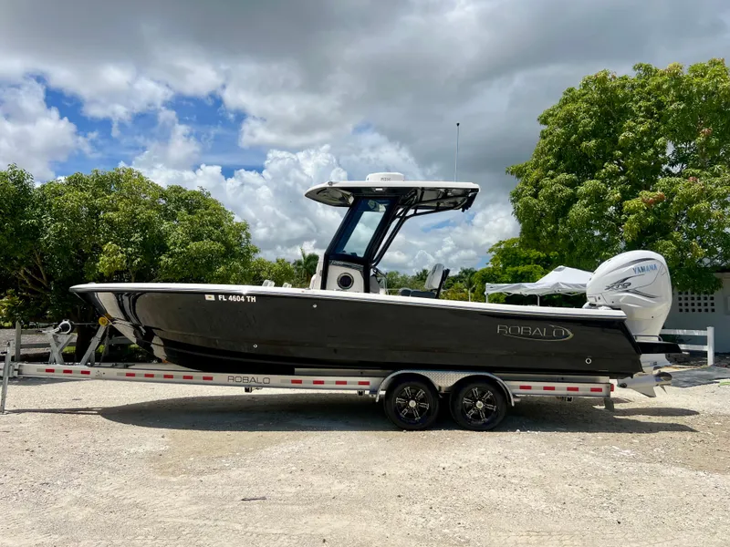Slide: The Image of 2022 Robalo 266 Cayman boat on a trailer, side view, outdoors. - 11