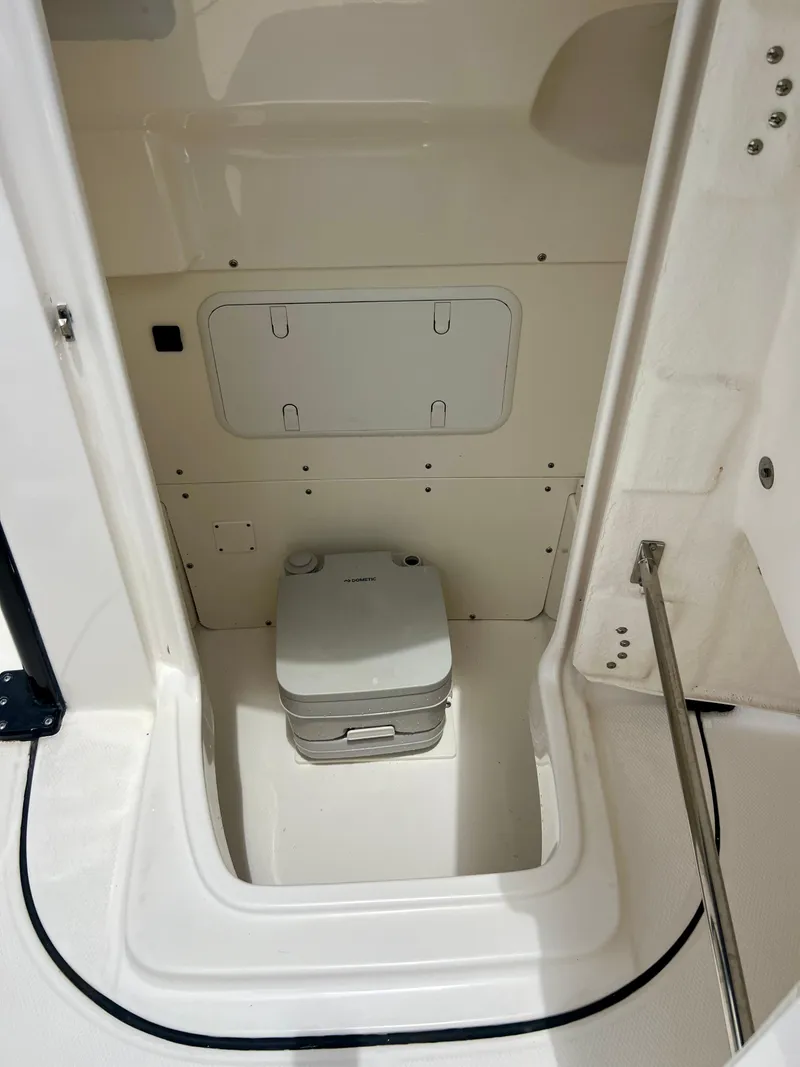 Slide: The Image of 2022 Robalo 266 Cayman boat interior with portable toilet. - 15