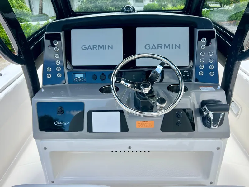 Slide: The Image of 2022 Robalo 266 Cayman boat helm with dual Garmin displays and steering wheel. - 16