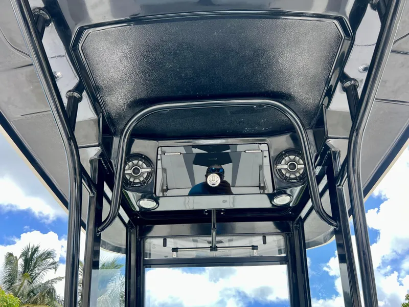 Slide: The Image of 2022 Robalo 266 Cayman T-top with speakers and lights against a blue sky. - 18