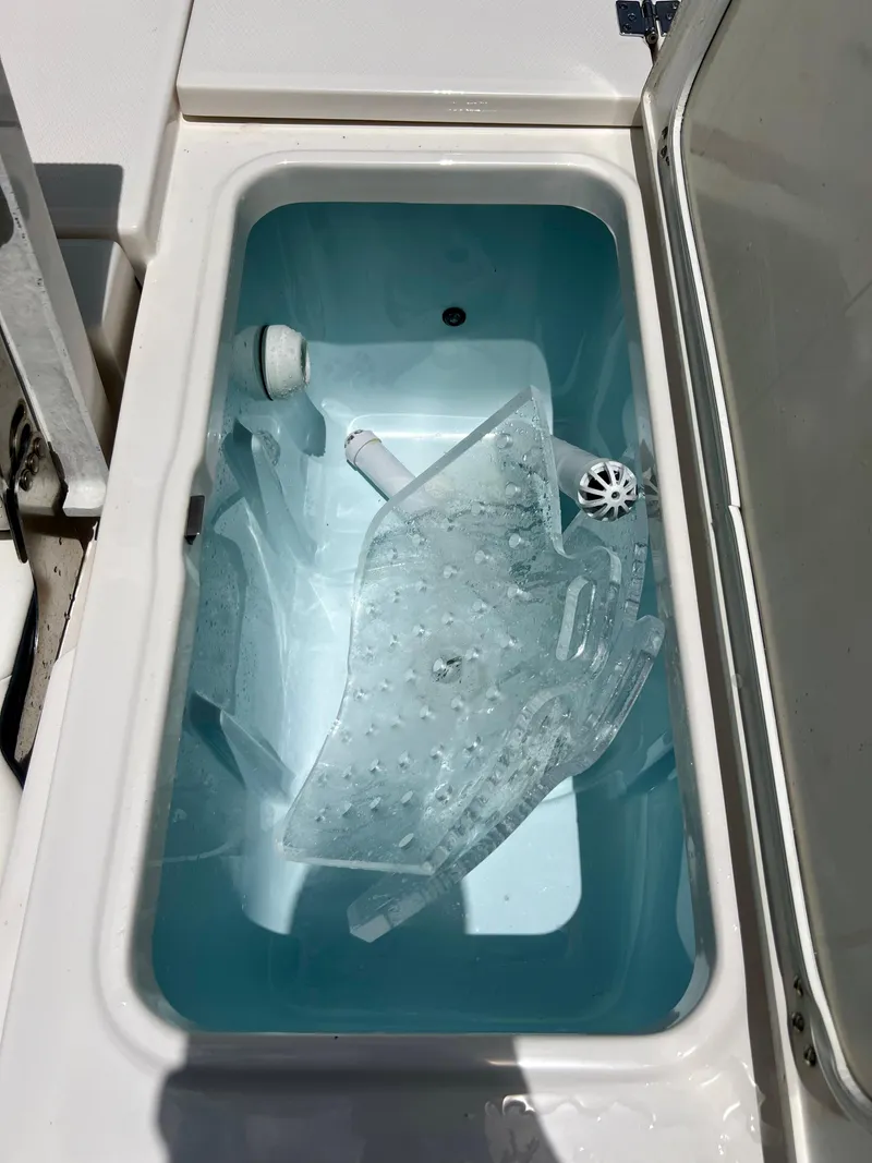 Slide: The Image of Livewell compartment of a 2022 Robalo 266 Cayman boat filled with water. - 20