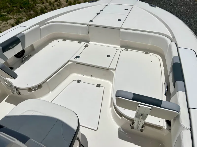 Slide: The Image of 2022 Robalo 266 Cayman boat interior with white seating and storage compartments. - 32
