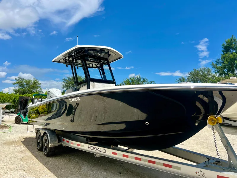 Slide: The Image of 2022 Robalo 266 Cayman boat on trailer under blue sky. - 5