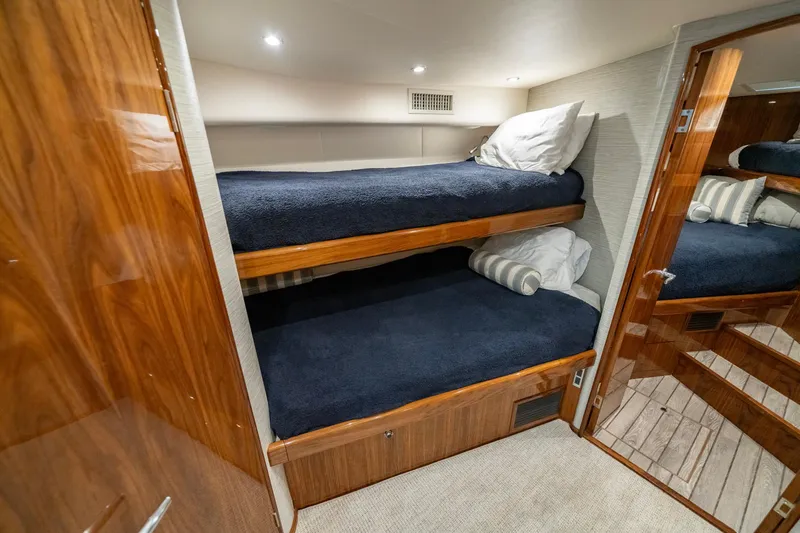 Slide: The Image of 2022 Viking 46 Billfish cabin with cozy bunk beds and wooden interior. - 25