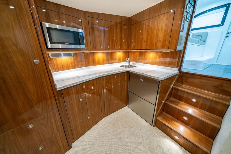 Slide: The Image of Luxurious 2022 Viking 46 Billfish yacht interior kitchen with wood cabinetry and modern appliances. - 29