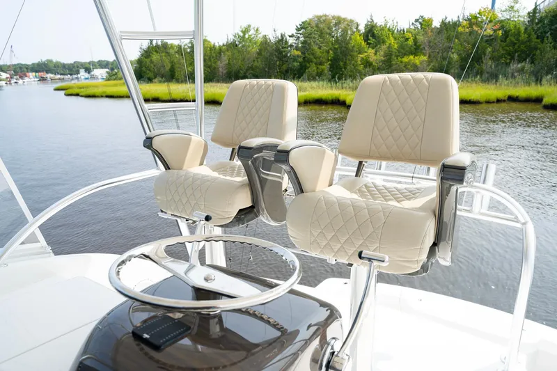 Slide: The Image of Luxury helm seats on 2022 Viking 46 Billfish boat, overlooking serene waterway. - 46
