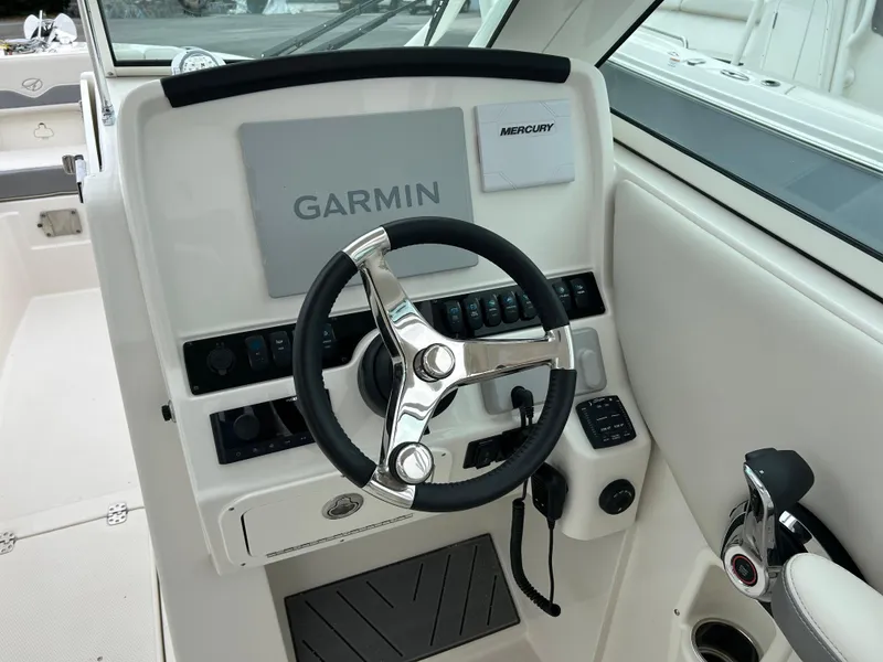 Slide: The Image of 2025 Sailfish 245 DC boat helm with Garmin navigation and Mercury controls. - 10