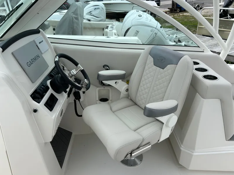 Slide: The Image of 2025 Sailfish 245 DC boat cockpit with Garmin navigation system and luxurious captain's chair. - 11