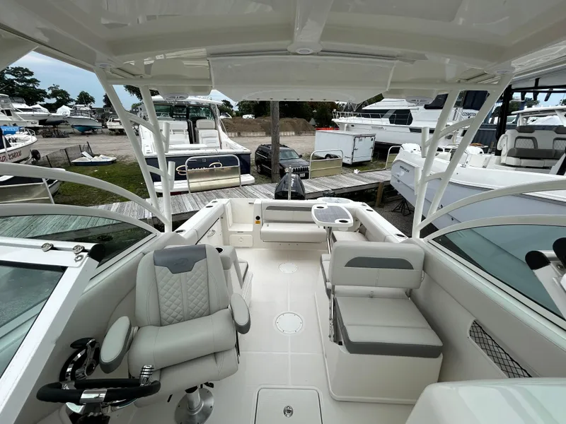 Slide: The Image of 2025 Sailfish 245 DC boat interior with seating and steering console. - 12