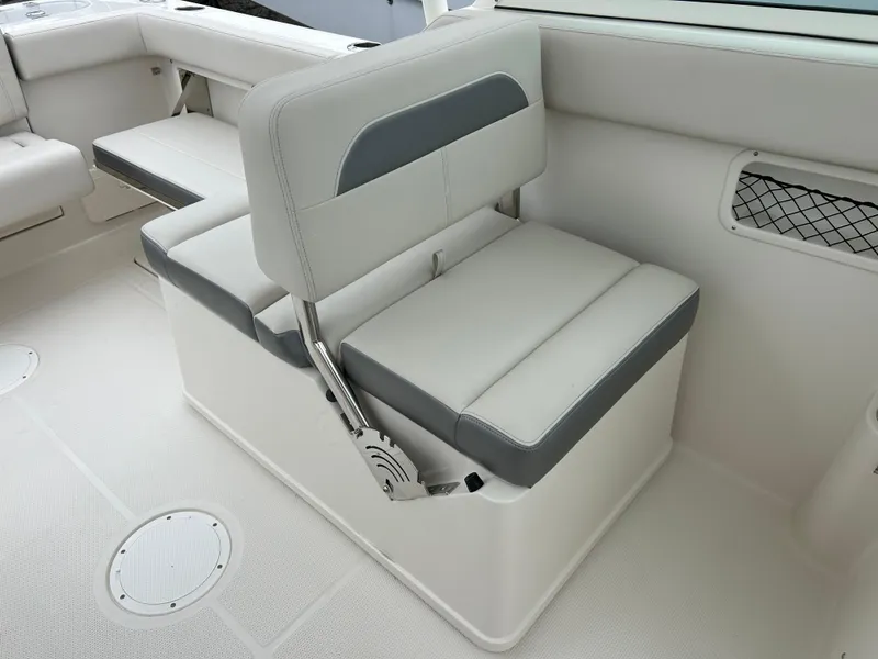 Slide: The Image of 2025 Sailfish 245 DC boat interior seating with white and gray upholstery. - 13