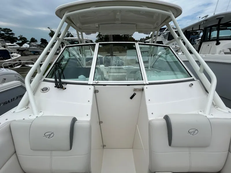 Slide: The Image of 2025 Sailfish 245 DC boat with white interior and windshield at marina. - 8