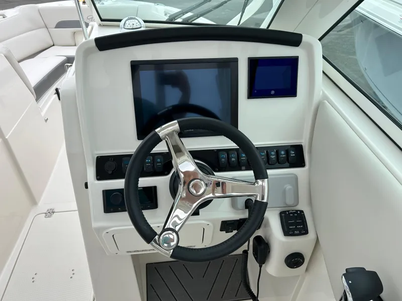 Slide: The Image of 2025 Sailfish 245 DC boat dashboard with steering wheel and digital displays. - 9
