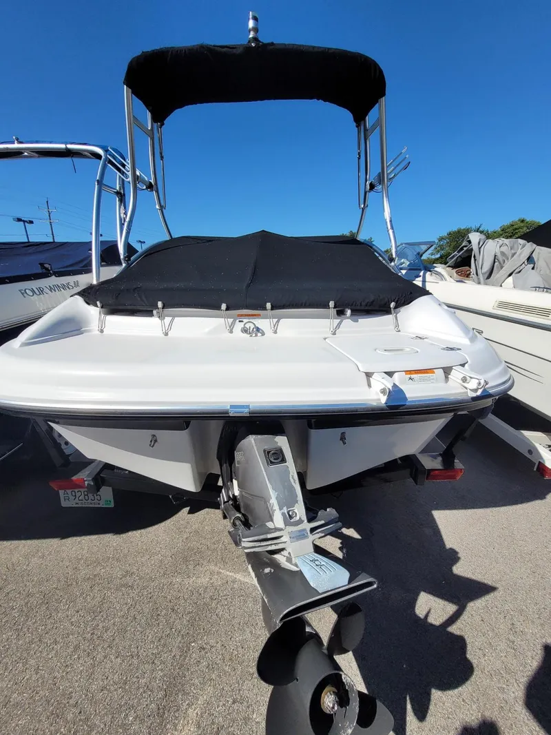 Slide: The Image of 2007 Four Winns 190 Horizon boat with black canopy and cover, parked on a sunny day. - 13