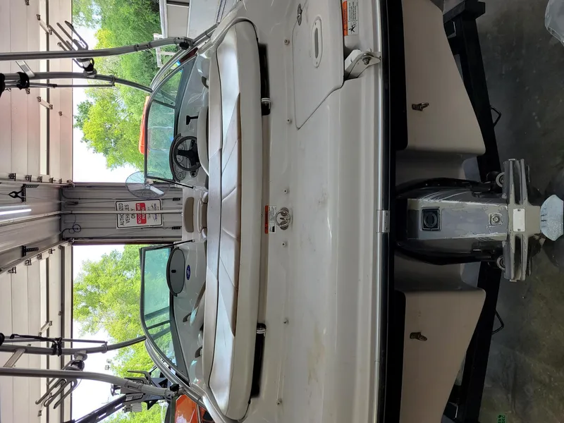 Slide: The Image of 2007 Four Winns 190 Horizon boat in garage, rear view, with visible outboard motor. - 22