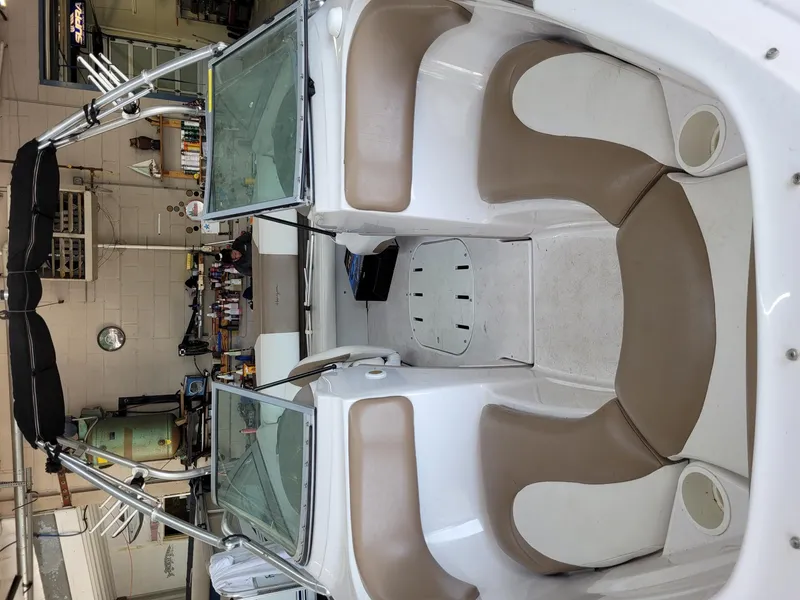 Slide: The Image of 2007 Four Winns 190 Horizon boat interior with beige seating in a garage. - 25