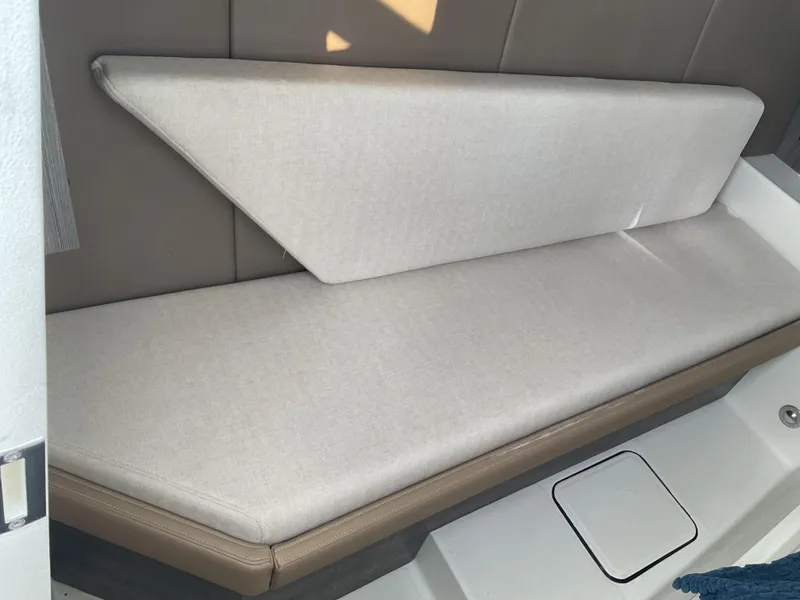 Slide: The Image of 2025 World Cat 400 DC-IS boat interior seating with beige cushions. - 18
