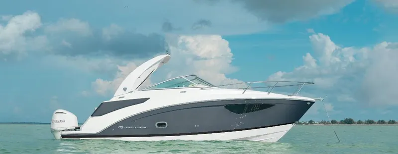 The Image of 2025 Regal 26 XO boat on calm water under a cloudy sky. - 0