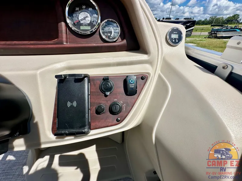 Slide: The Image of Control panel of 2025 South Bay 220CR LE pontoon boat with gauges and phone holder. - 18