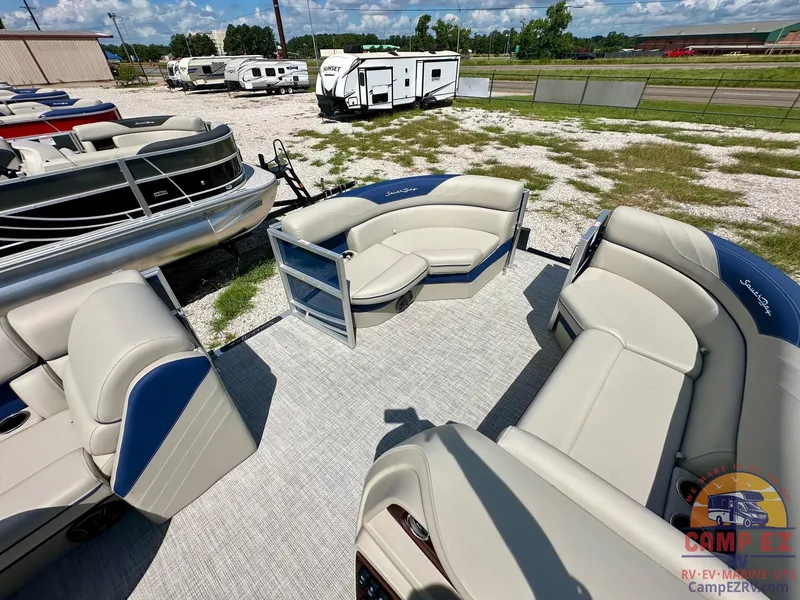 Slide: The Image of 2025 South Bay 220CR LE pontoon boat with spacious seating, displayed at an outdoor dealership. - 22