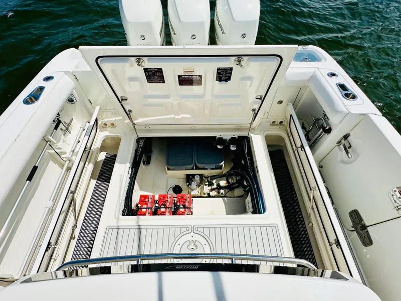 Slide: The Image of 2016 Boston Whaler 350 Outrage boat engine compartment with open hatch and visible equipment. - 17