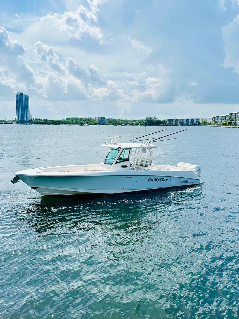 Slide: The Image of 2016 Boston Whaler 350 Outrage boat on calm water under a cloudy sky. - 2