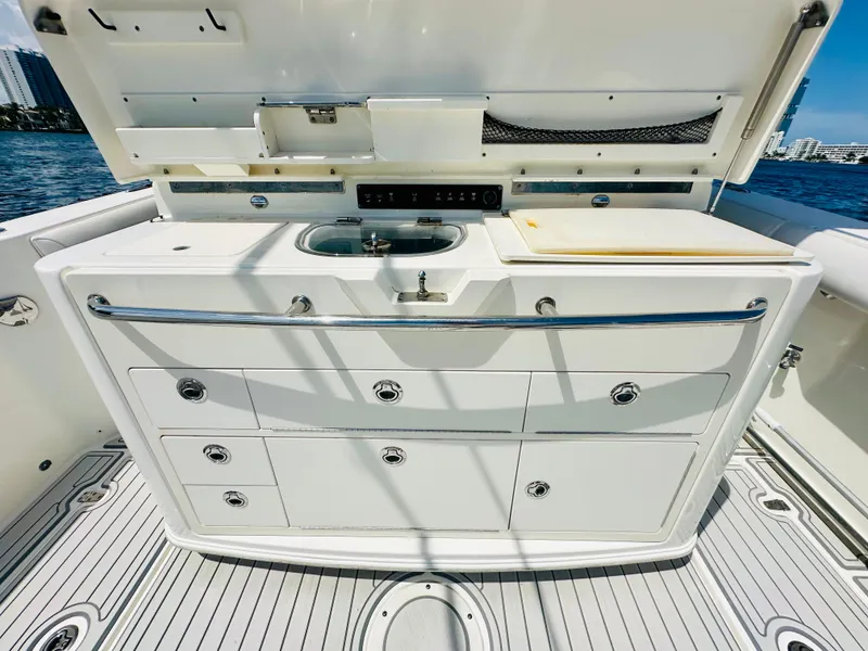Slide: The Image of 2016 Boston Whaler 350 Outrage boat kitchen with sink and storage drawers. - 22