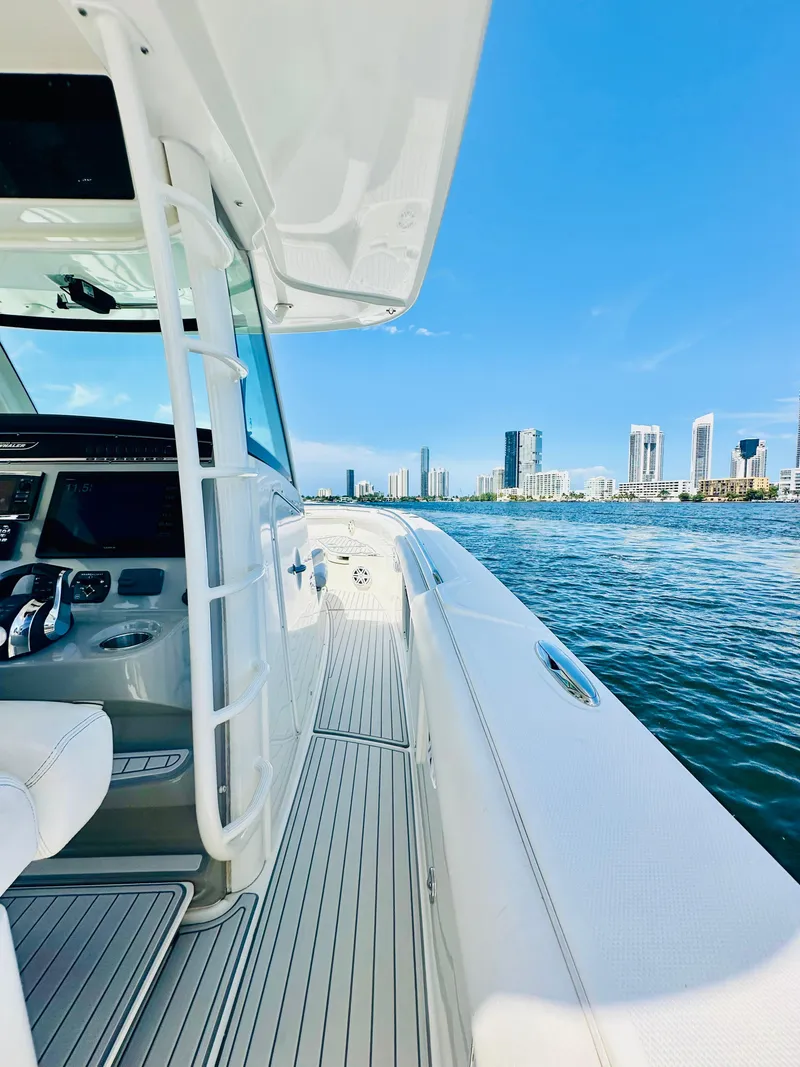 Slide: The Image of 2016 Boston Whaler 350 Outrage on water, city skyline in background, clear blue sky. - 25