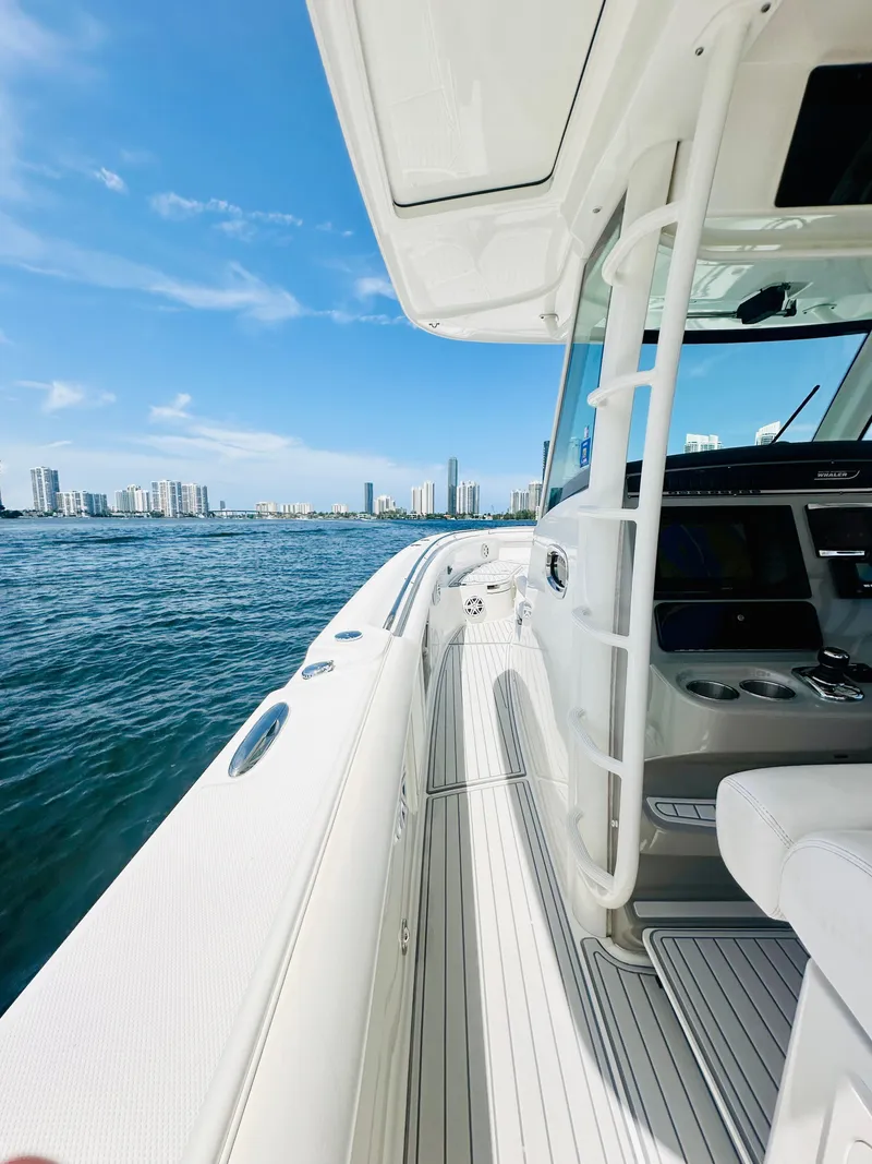 Slide: The Image of 2016 Boston Whaler 350 Outrage on water, city skyline in background, clear blue sky. - 26