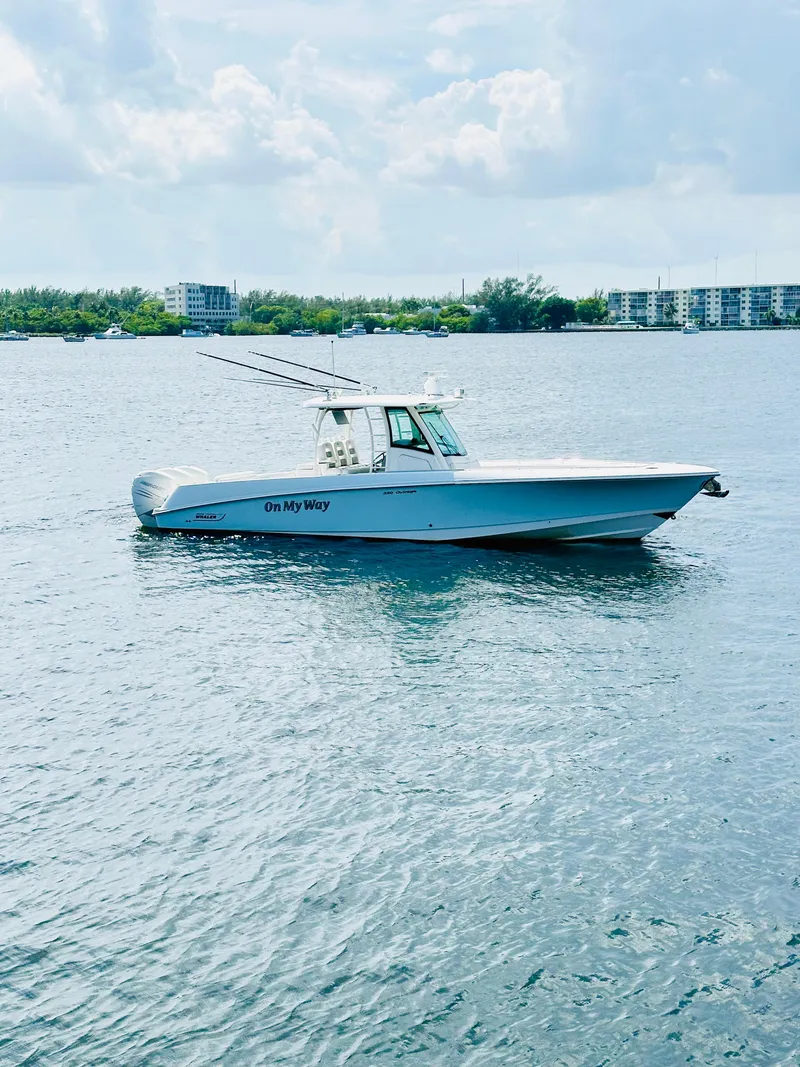 Slide: The Image of 2016 Boston Whaler 350 Outrage boat on calm water with buildings in the background. - 5