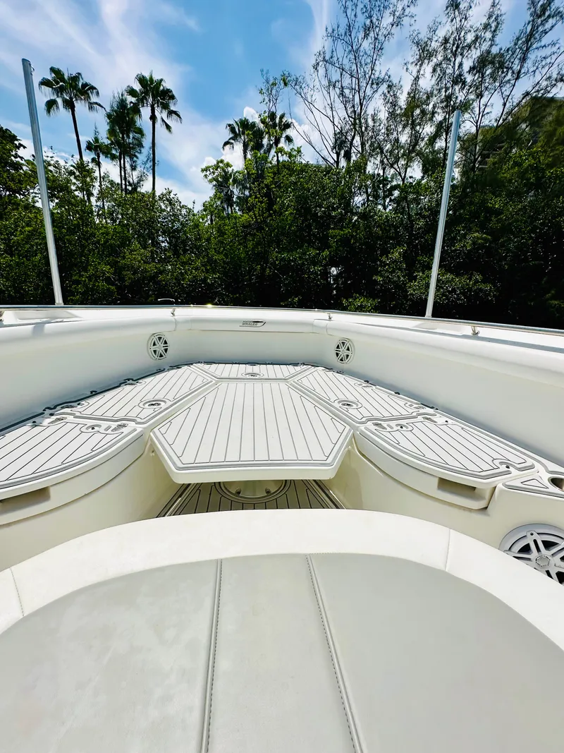 Slide: The Image of 2016 Boston Whaler 350 Outrage boat deck with lush greenery and palm trees in background. - 7