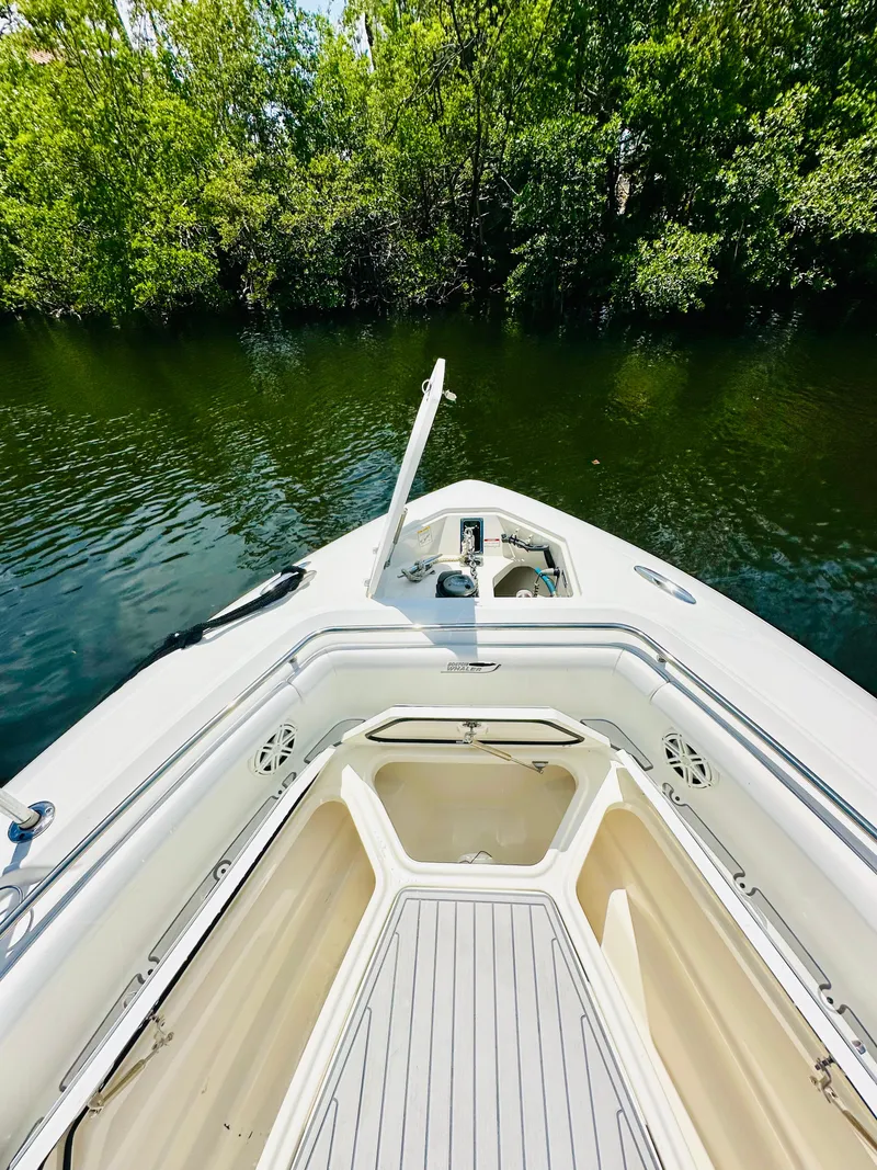 Slide: The Image of 2016 Boston Whaler 350 Outrage boat on calm water, surrounded by lush greenery. - 8