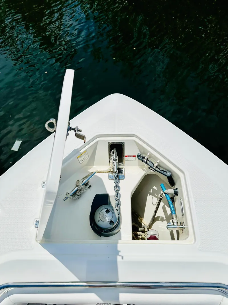 Slide: The Image of 2016 Boston Whaler 350 Outrage anchor compartment with chain, docked on water. - 9