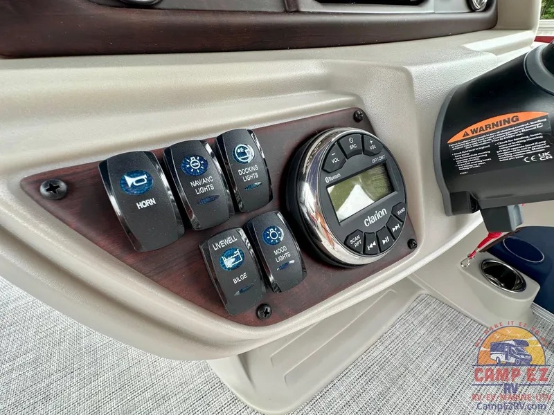 Slide: The Image of Control panel of 2025 South Bay 224CR LE boat with switches and Clarion display. - 15