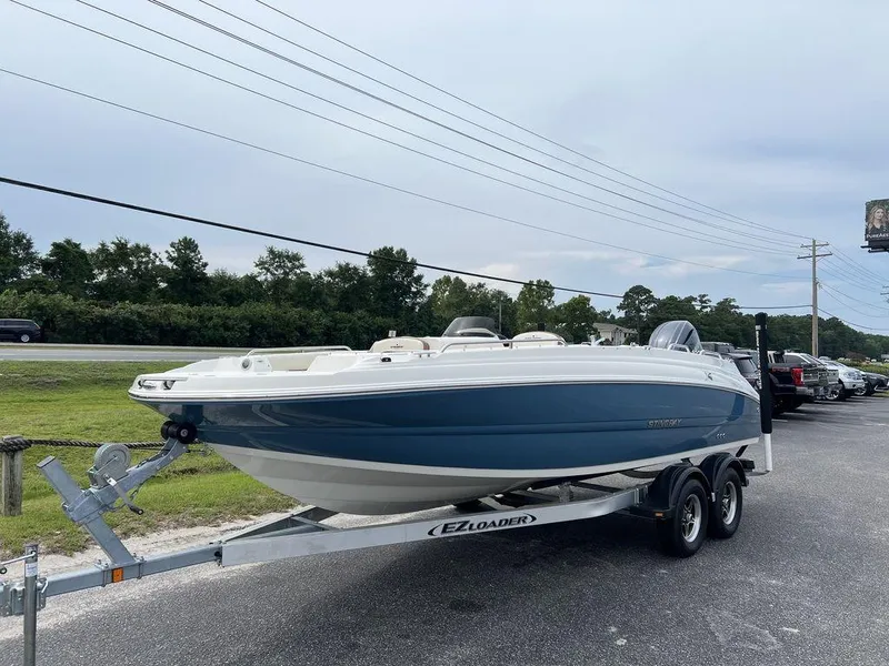 Slide: The Image of 2024 Stingray 212SC boat on EZ Loader trailer, parked outdoors. - 3