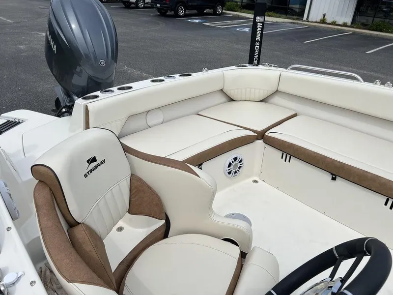 Slide: The Image of 2024 Stingray 212SC boat interior with cushioned seating and steering wheel. - 8