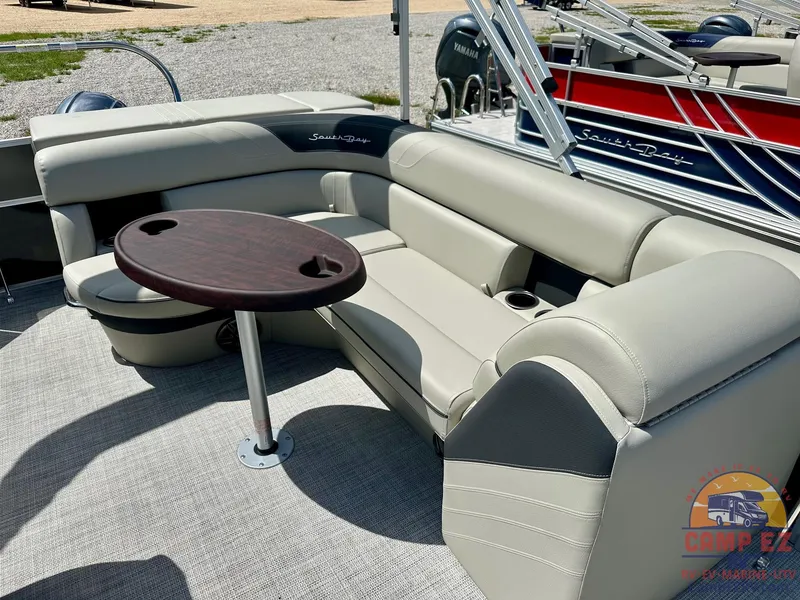 Slide: The Image of 2025 South Bay 220CR LE pontoon boat with beige seating and round table. - 16