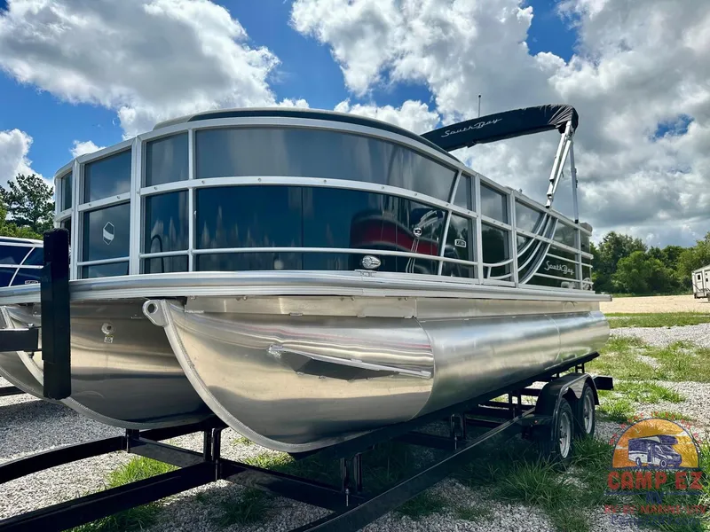Slide: The Image of 2025 South Bay 220CR LE pontoon boat on a trailer under a cloudy sky. - 4