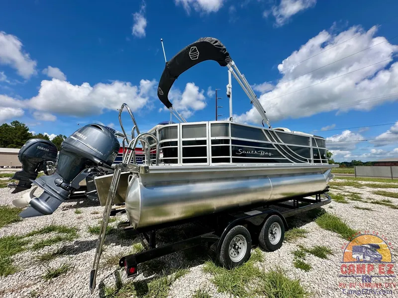 Slide: The Image of 2025 South Bay 220CR LE pontoon boat on trailer under blue sky. - 8
