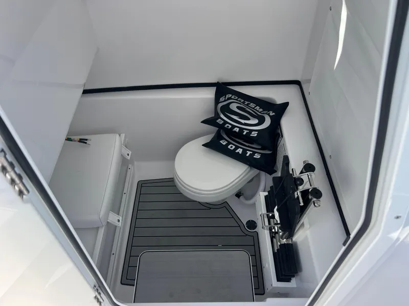 Slide: The Image of 2025 Sportsman Open 282 Center Console boat interior with toilet and branded cushion. - 19