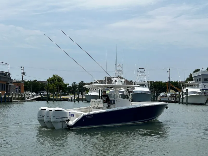 Slide: The Image of 2016 Jupiter 34 HFS boat with triple Yamaha F300 engines docked in a marina. - 16