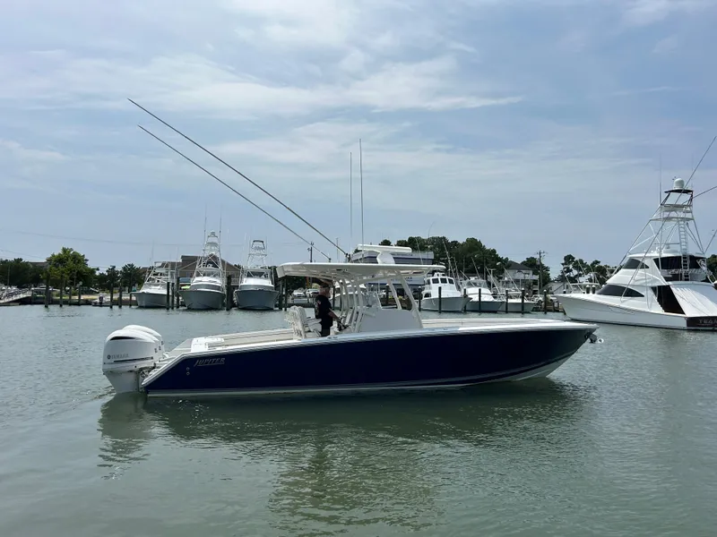 Slide: The Image of 2016 Jupiter 34 HFS boat with Triple Yamaha F300 engines docked in a marina. - 21