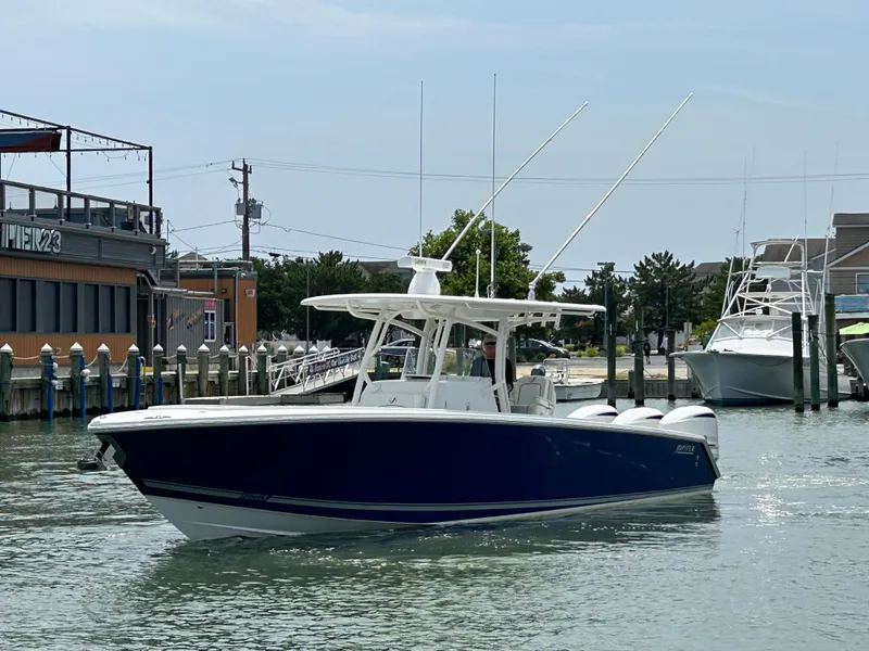 Slide: The Image of 2016 Jupiter 34 HFS boat with Triple Yamaha F300 engines docked in a marina. - 3