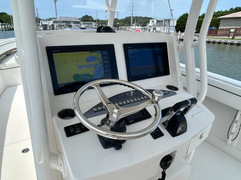 Slide: The Image of 2016 Jupiter 34 HFS boat helm with dual navigation screens and steering wheel. - 41