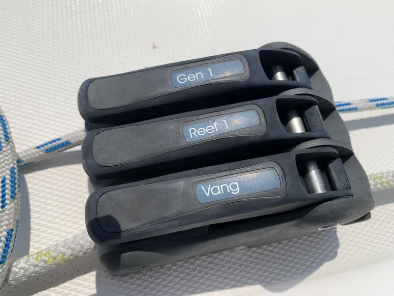 Slide: The Image of Close-up of sailing rope clutches labeled Gen 1, Reef 1, Vang on a 2017 Sparkman & Stephens 30. - 12