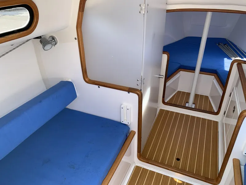Slide: The Image of Interior of 2017 Sparkman & Stephens 30 sailboat with blue cushions and wood accents. - 15